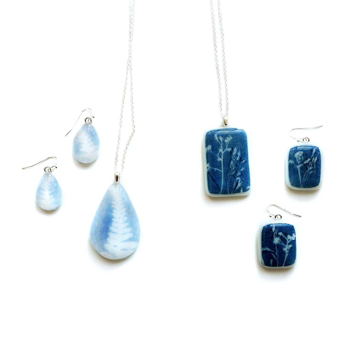 Jewelry set with blue and white floral patterned glass pendants on a light background